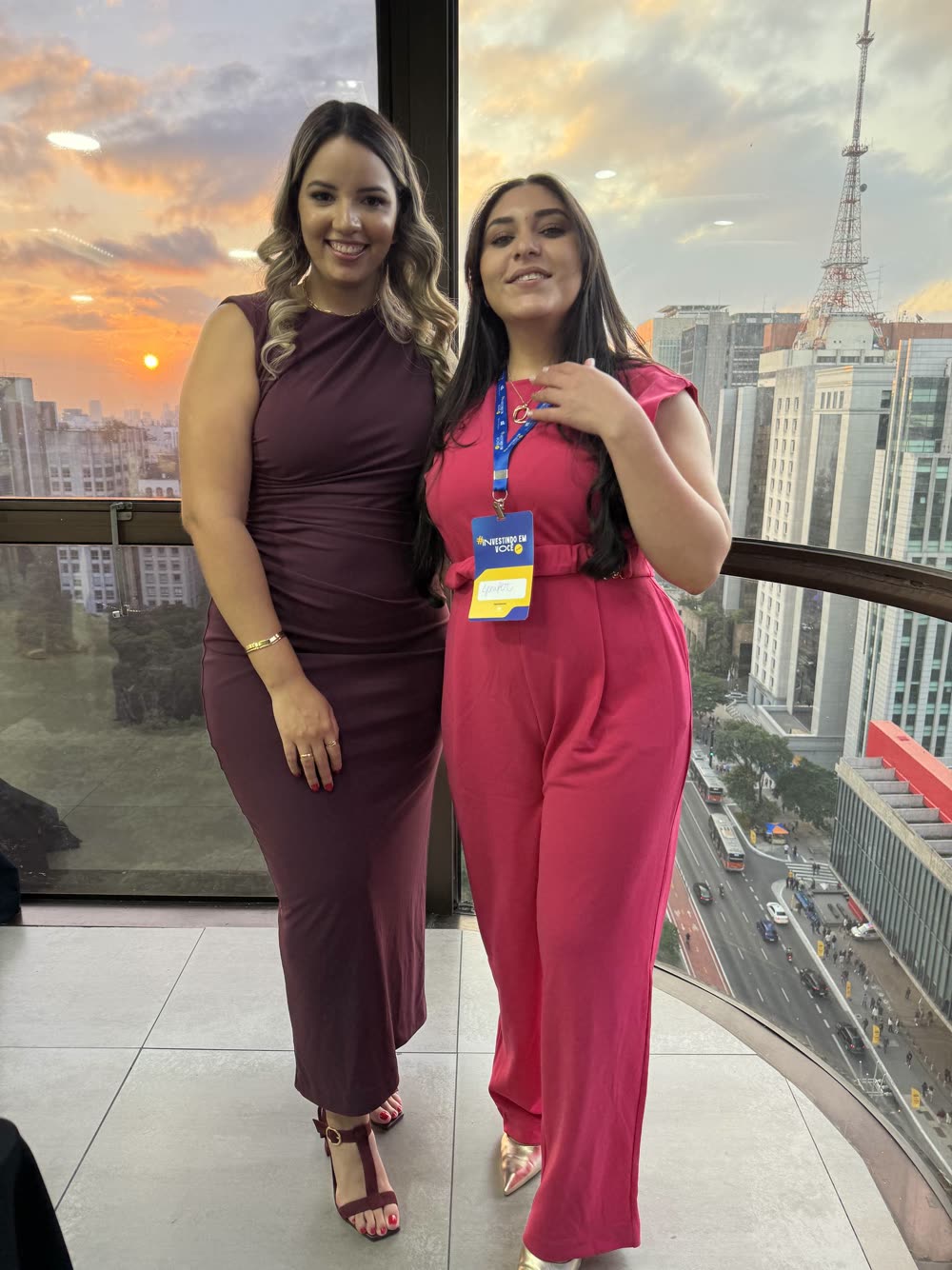 Stefany com uma participante no fim de tarde, com a cidade ao fundo, na edição de 2025