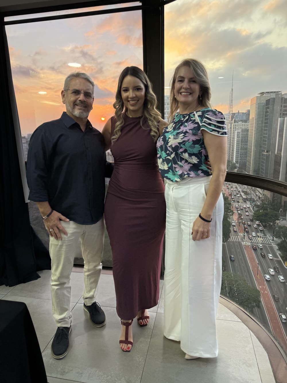 Stefany com dois participantes, posando no fim de tarde da edição de 2025