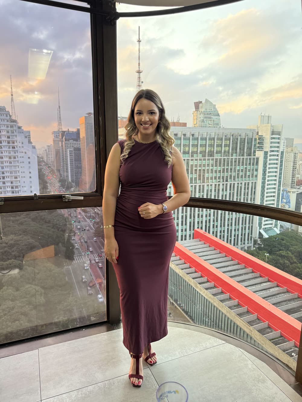 Stefany de corpo inteiro no fim de tarde, com a cidade ao fundo, na edição de 2025